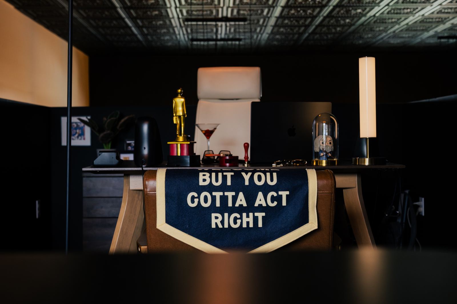 A desk at bahlr HQ with a pennant that reads: all y'all are welcome, but you gotta act right