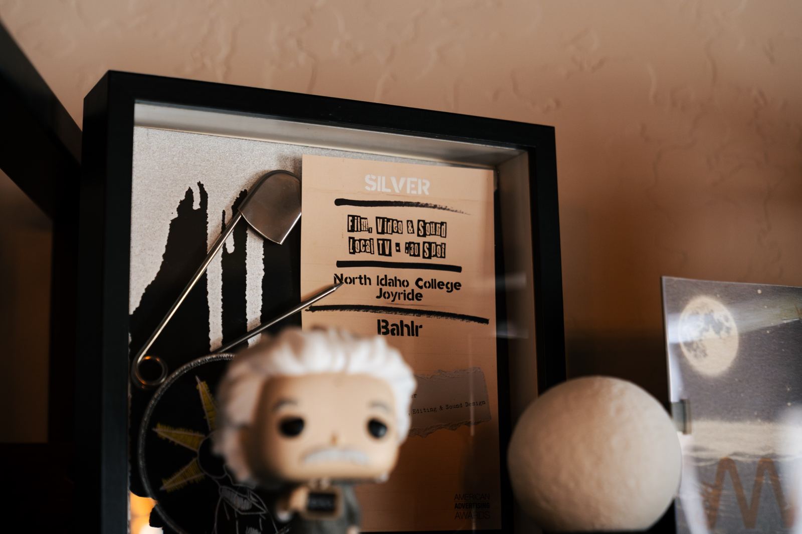 A framed Silver American Advertising Award for a North Idaho College TV spot by bahlr