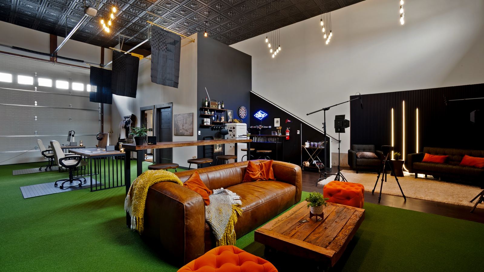 The bahlr studio floor with an interview set, lights and boom mics beside the lounge